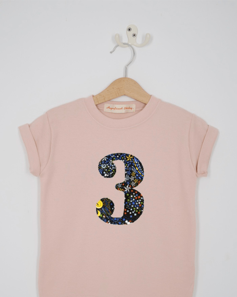 a pink 3rd birthday t-shirt with a number 3 cut from Adelajda Space liberty print on the front