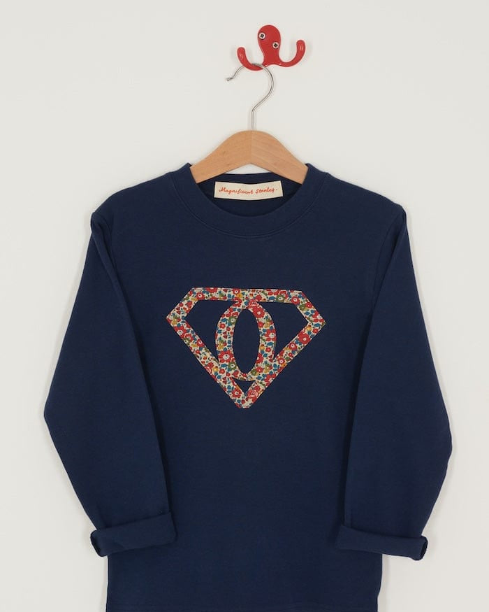 A personalised navy t-shirt with a superhero motif initial made from floral Liberty print fabric.