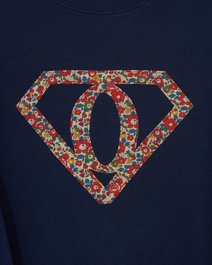 A personalised navy t-shirt with a superhero motif initial made from floral Liberty print fabric.