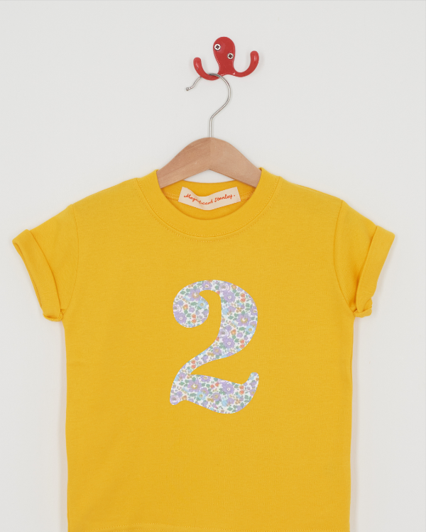 a yellow birthday t-shirt with a number 2 cut from betsy purple liberty floral print on the front.