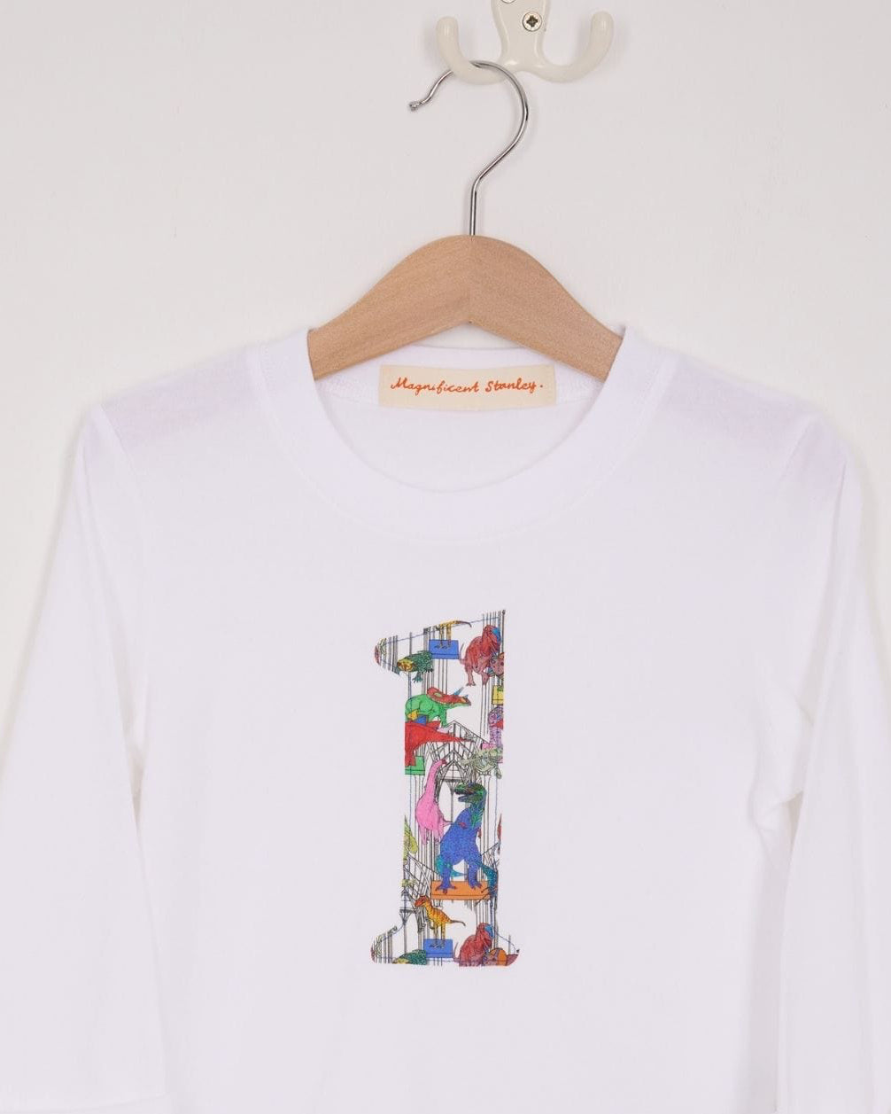 a white birthday t-shirt with a number 1 cut from liberty dinosaur print on the front