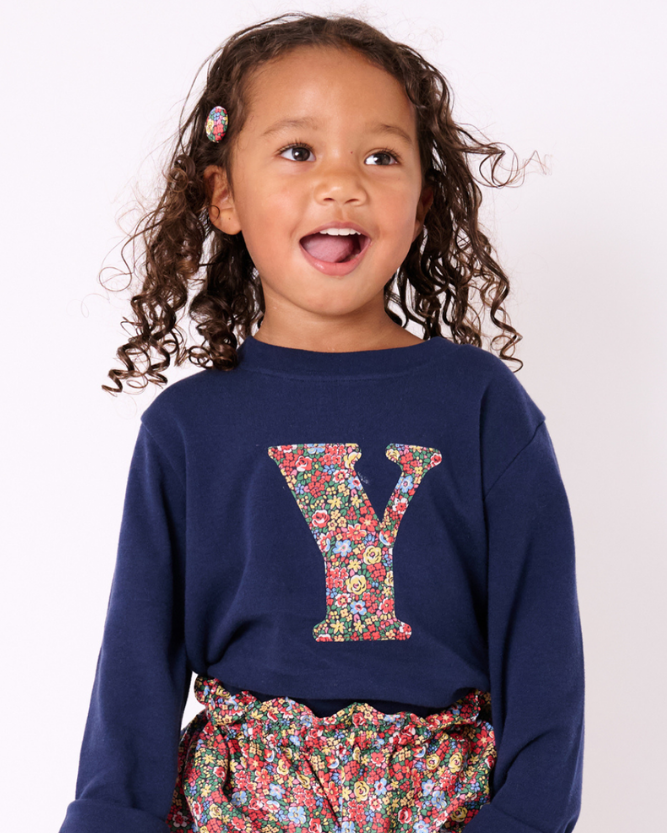 a 3 year old girl wearing a navy cotton t-shirt with the number 2 on the front cut from emma louise liberty print