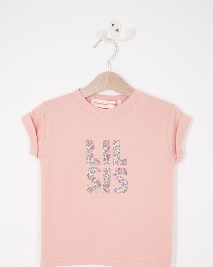 a pink little sister sibling t-shirt with the words Lil Sis on the front cut from floral Liberty print.