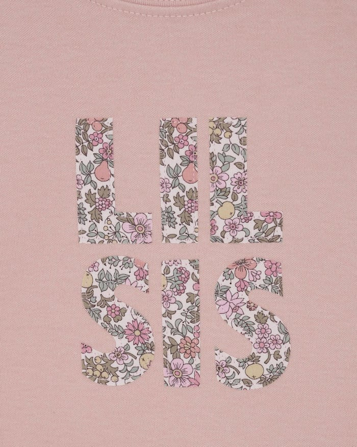 a pink little sister sibling t-shirt with the words Lil Sis on the front cut from floral Liberty print.