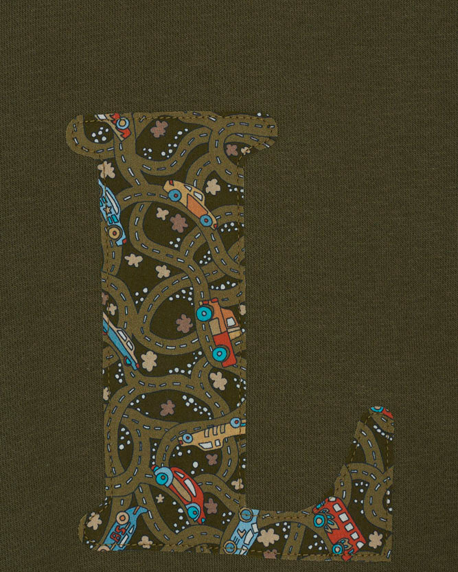 A khaki sweatshirt with an initial on the front. The initial is made from vintage cars Liberty print.