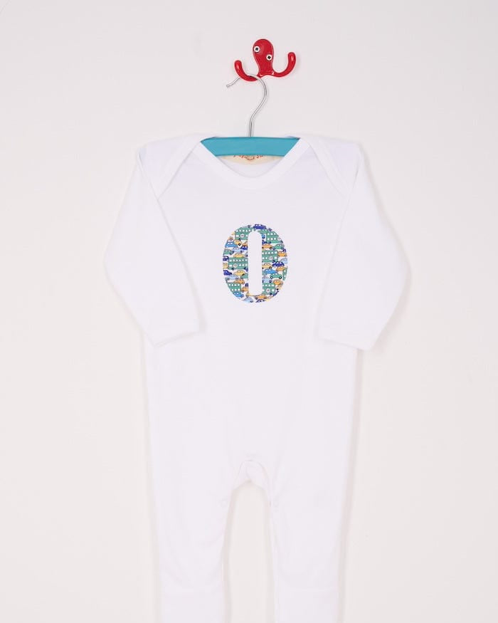 a personalised cotton baby romper with his initial on the front in hop on hop off liberty print featuring cars and London buses.