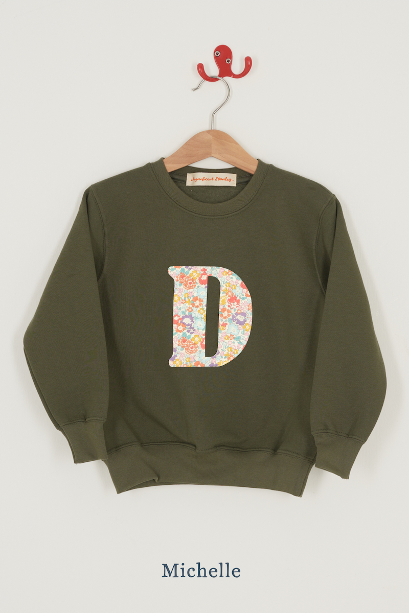 a personalised khaki sweater with a large letter 'D' in michelle liberty print.