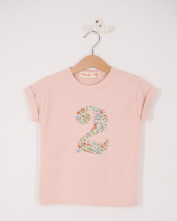 A Pink t-shirt with a Liberty Nazanin floral number '2' on a hanger against a white background