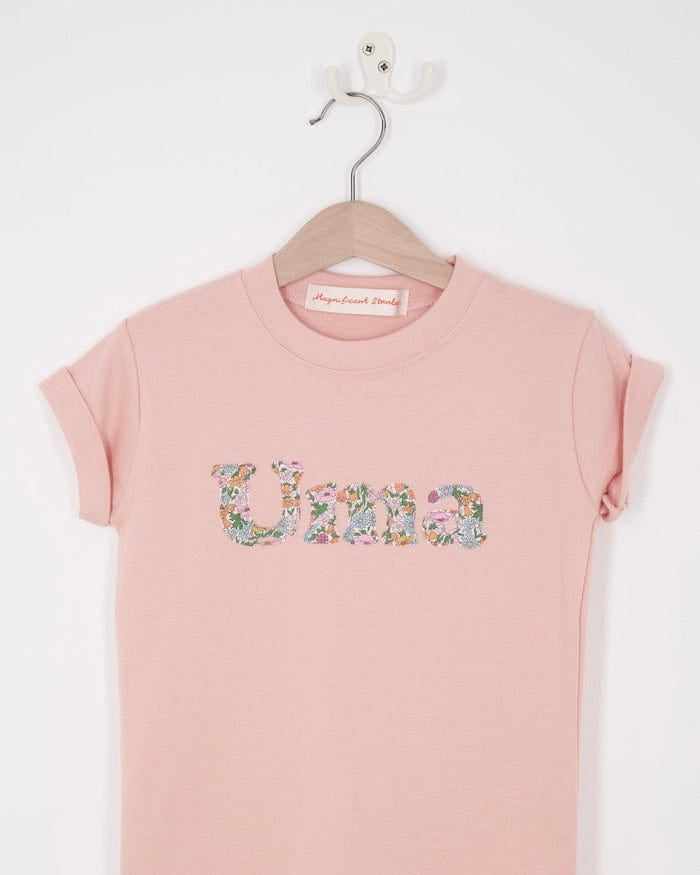 A soft pink kids t-shirt with her name cut from Liberty print in lowercase letters.