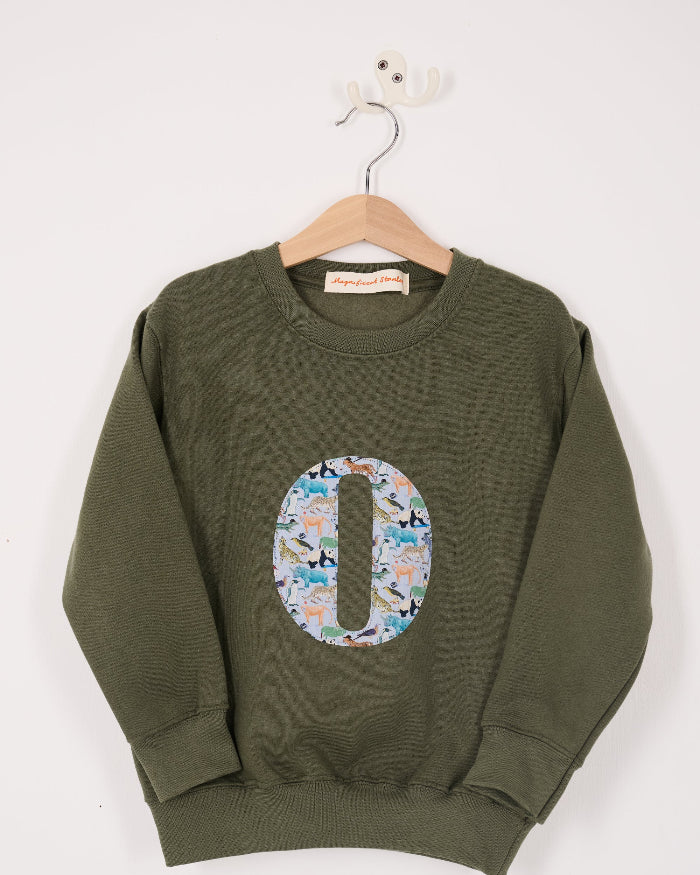 a personalised khaki sweater with a large letter 'O' in Quey 2 liberty animal print.