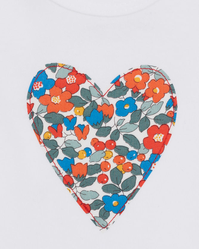 Heart-shaped fabric patch with floral pattern on a white background