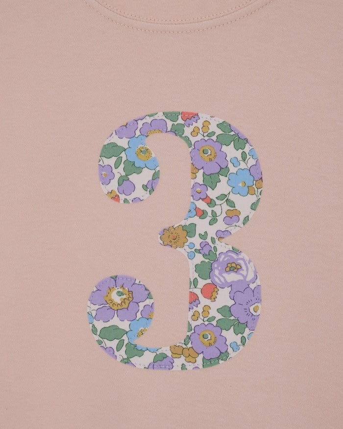 a pink birthday t-shirt with a number 3 cut from betsy purple liberty floral print on the front