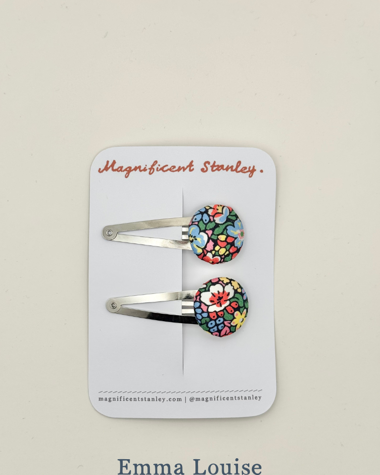 Two floral hair clips in liberty emma louise on a 'Magnificent Stanley' branded card.