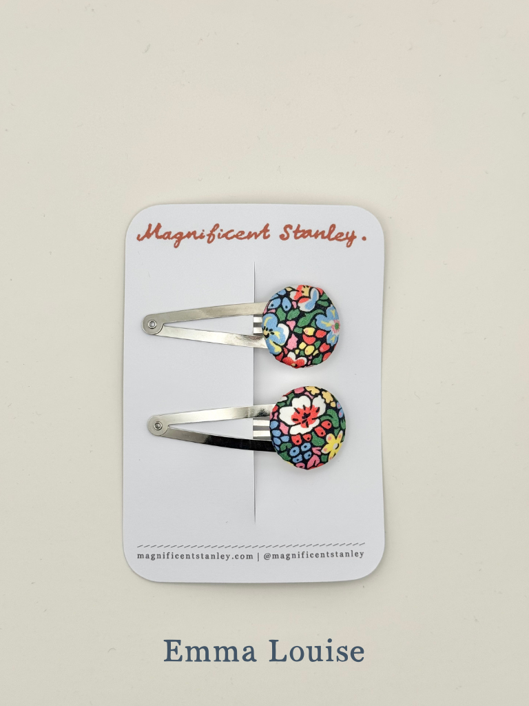 Two floral hair clips in liberty emma louise on a 'Magnificent Stanley' branded card.