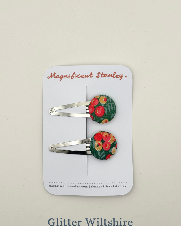 Pair of floral glitter wiltshire hair clips on a 'Magnificent Stanley' branded card.