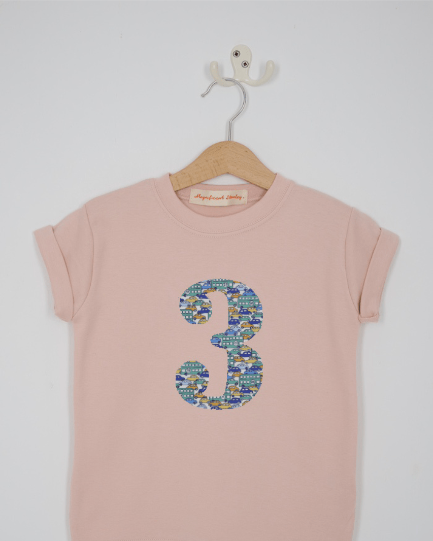 a pink 3rd birthday t-shirt with a number 3 cut from hop on hop off liberty london bus and car print on the front