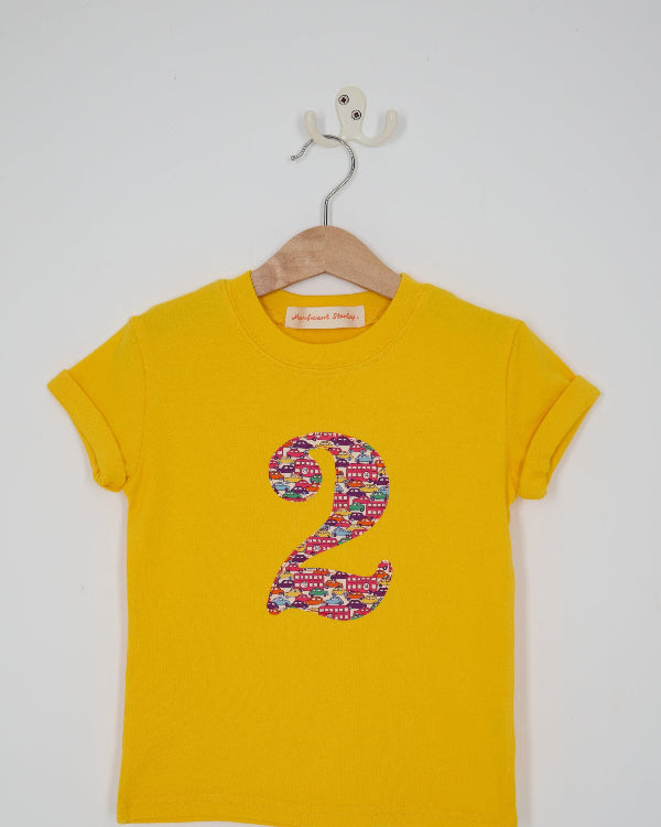 a yellow kids t-shirt with a number 3 cut from Hop on hop off red cars and london bus liberty print on the front.