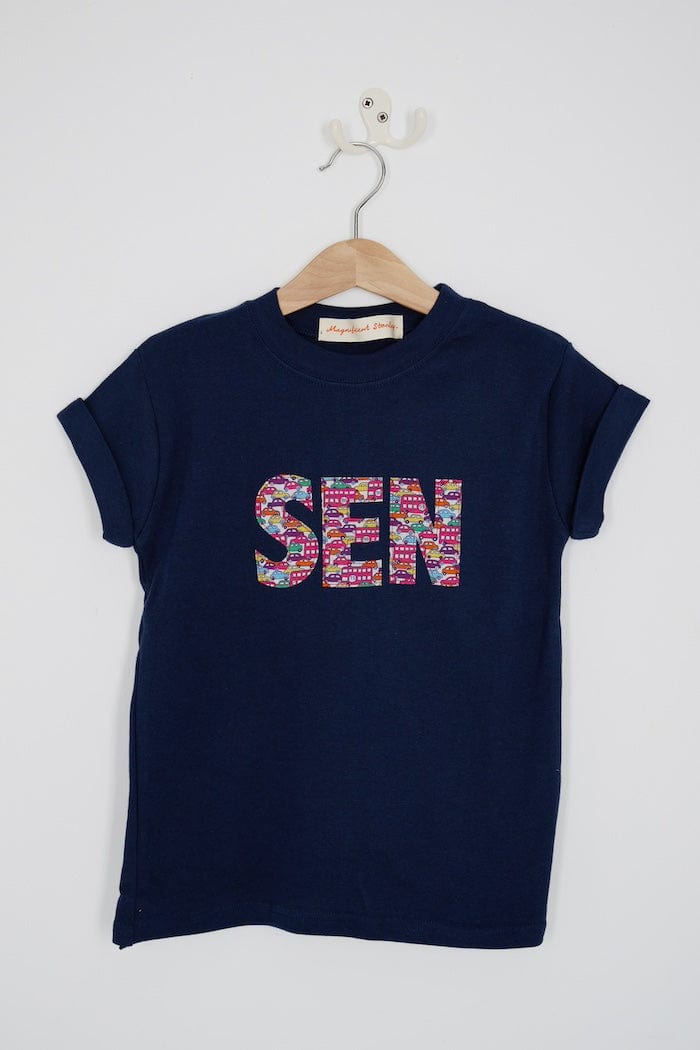 A navy cotton personalised t-shirt with his name on cut from liberty print featuring London buses and vintage cars.