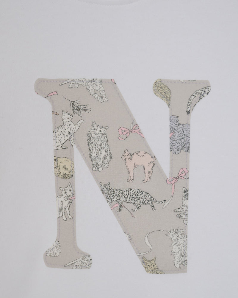 A large embroidered letter 'N' featuring a Liberty Koh & Eito cat print on a light beige background, shown on a plain white fabric.