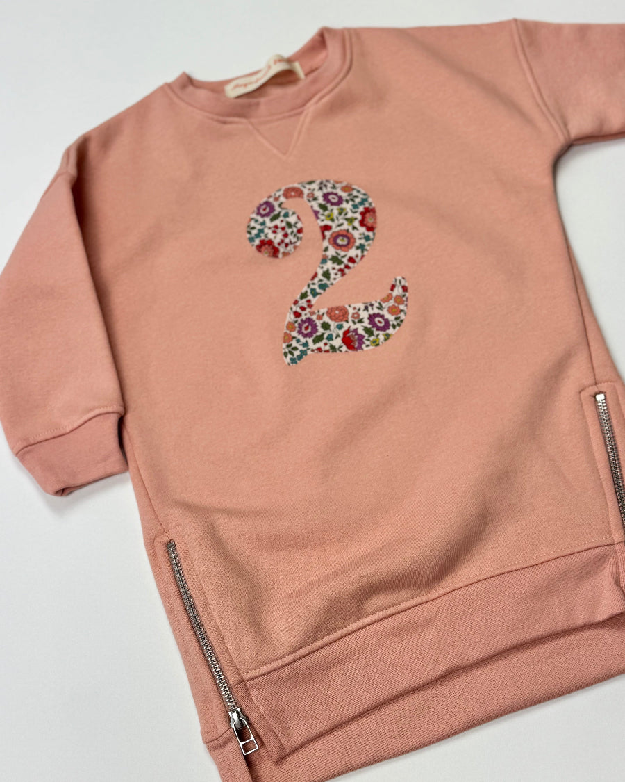 Pink sweatshirt dress with a liberty floral number '2' on a white background