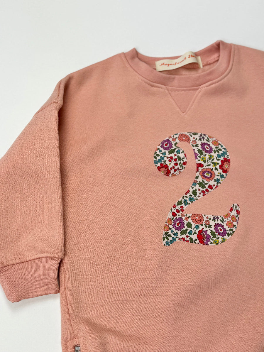 Pink sweatshirt with Liberty floral number '2' on a white background