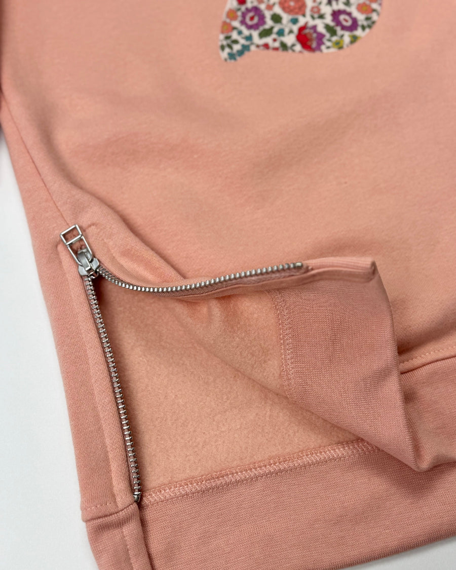 Pink sweatshirt dress with a liberty floral design showing the side zips area.