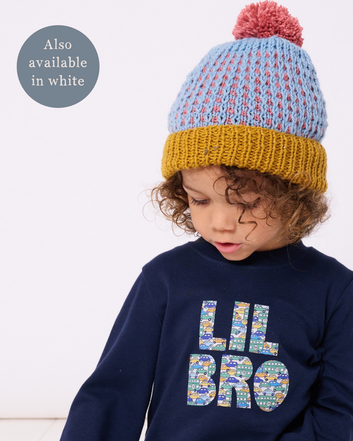 A 3 year old boy little brother wearing a cotton navy t-shirt with the words lil bro on the front cut from Liberty cars and buses print.