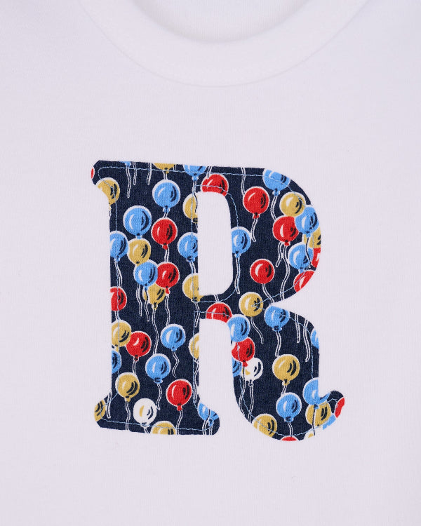 a Personalised Bodysuit in Ethan's Party Liberty Print, a close up showing the applique stitching