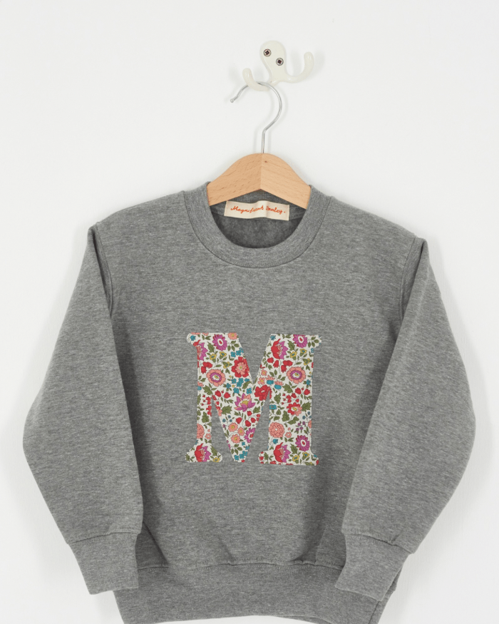 A personalised grey kids sweatshirt with an initial on in floral Liberty fabric.