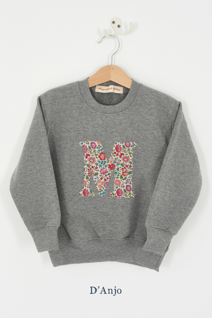 A personalised grey kids sweatshirt with an initial on in floral Liberty fabric.