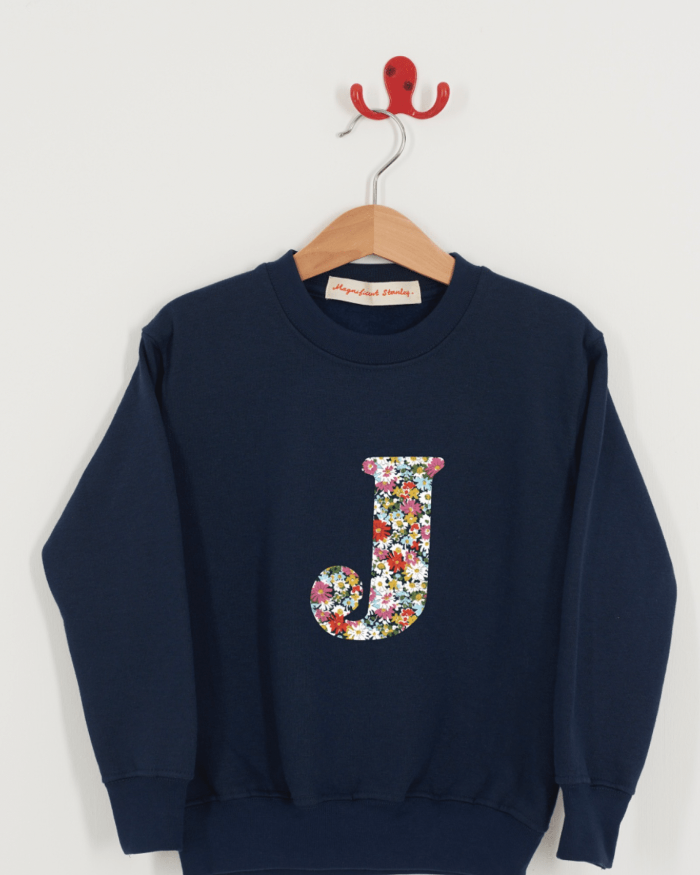 A personalised kids navy sweatshirt with an initial on in LIbby floral Liberty fabric.