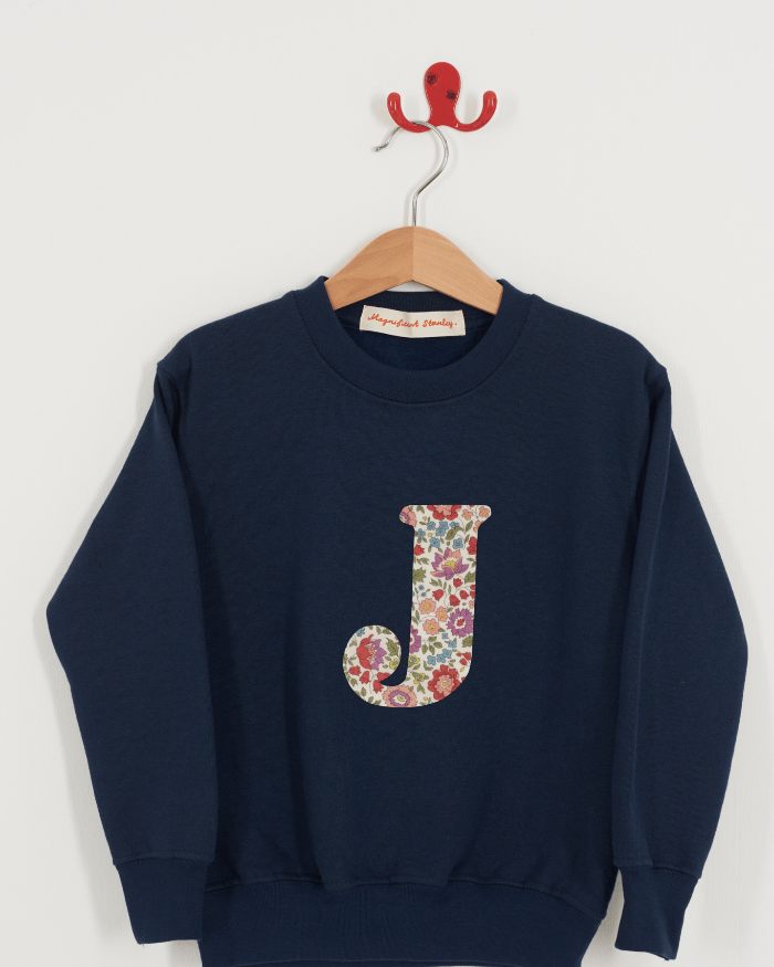 A personalised navy kids sweatshirt with an initial on in floral Liberty fabric.