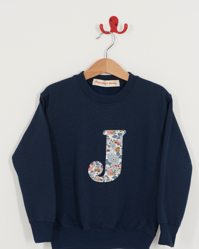A personalised navy sweatshirt with an initial on in Betsy Grey Liberty fabric.