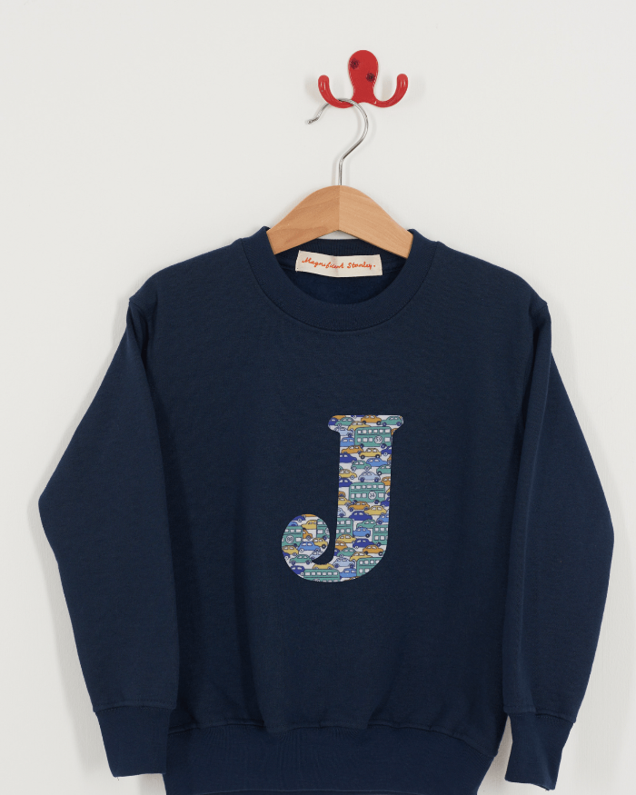 A Magnificent Stanley kids personalised Navy Sweatshirt with an initial on the front in hop on hop off cars liberty print.