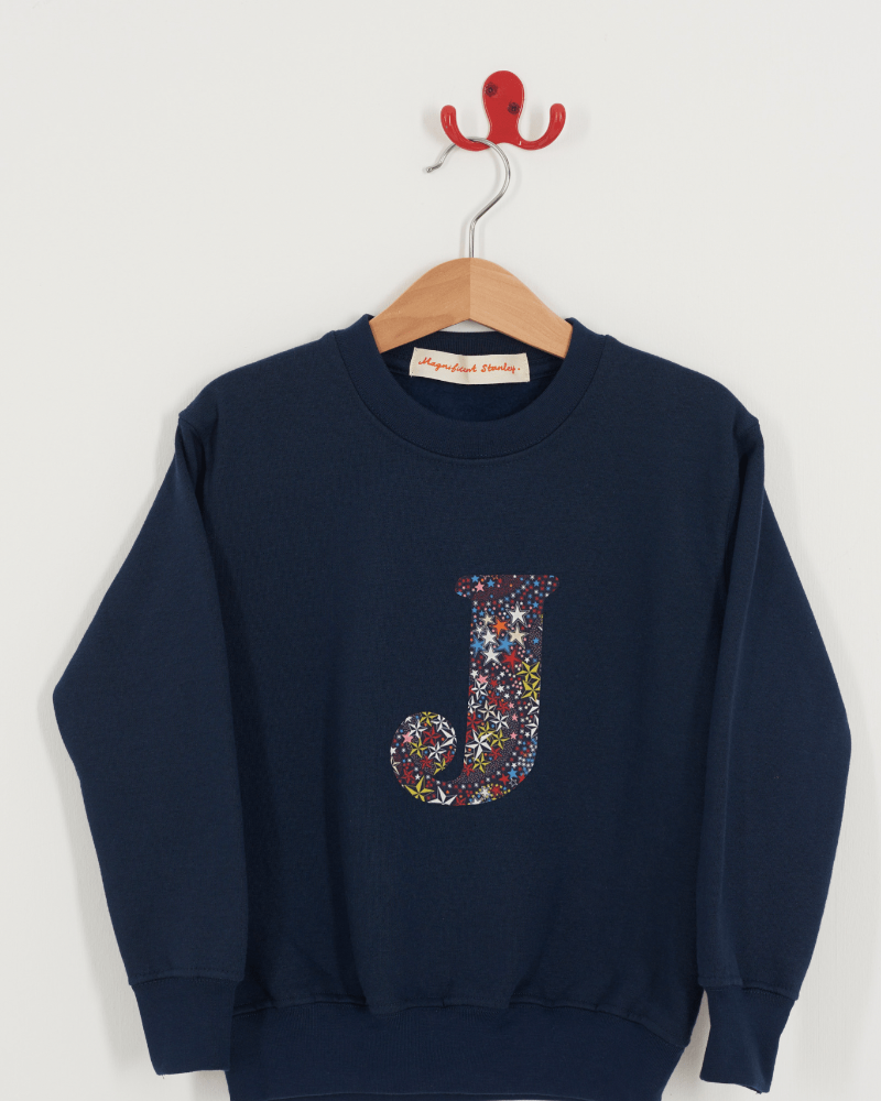 A personalised navy sweatshirt with an initial on in Adelajda's Wish Liberty fabric.