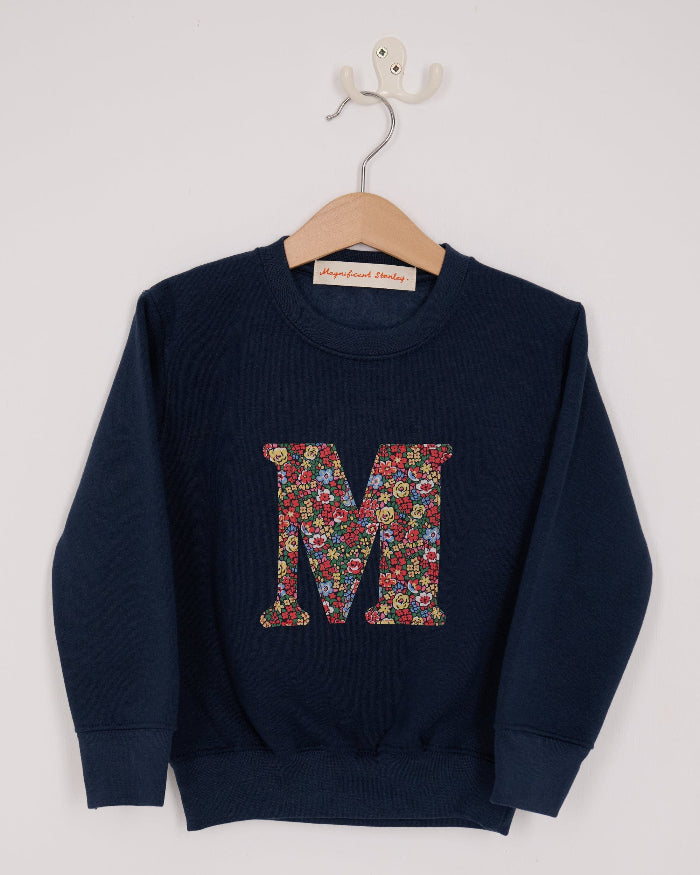 A navy Magnificent Stanley personalised Navy Sweatshirt with her initial on the front in floral emma louise liberty print.