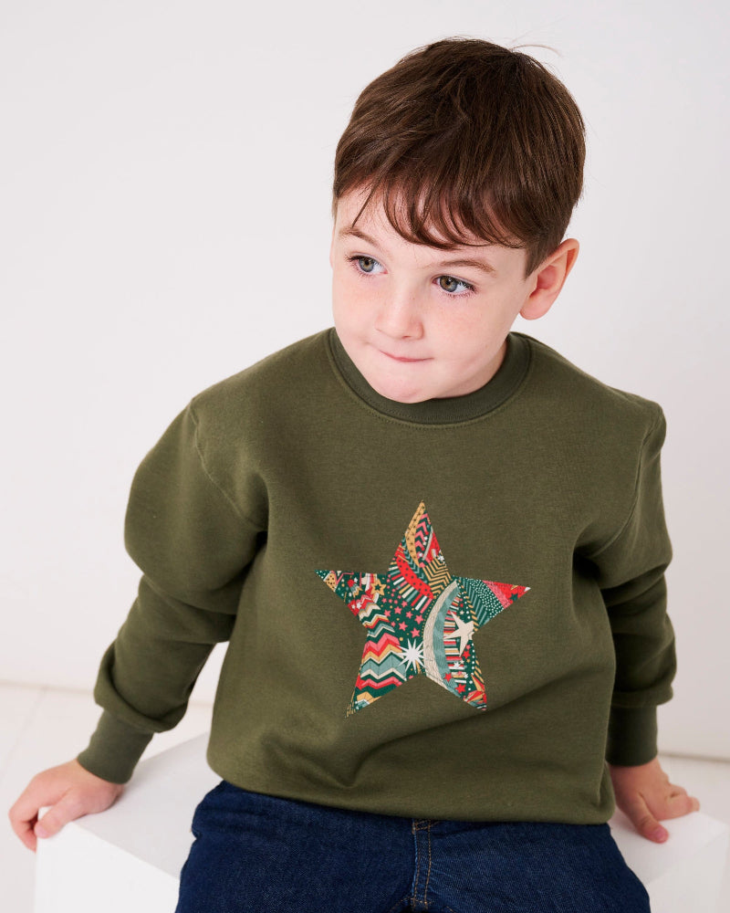 a 5 year old wearing a Magnificent Stanley Khaki Christmas Jumper Sweatshirt with a star on the front made from Liberty Print fabric.