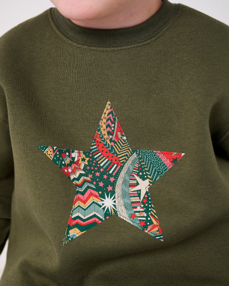 a 5 year old wearing a Magnificent Stanley Khaki Christmas Jumper Sweatshirt with a star on the front made from Liberty Print fabric.