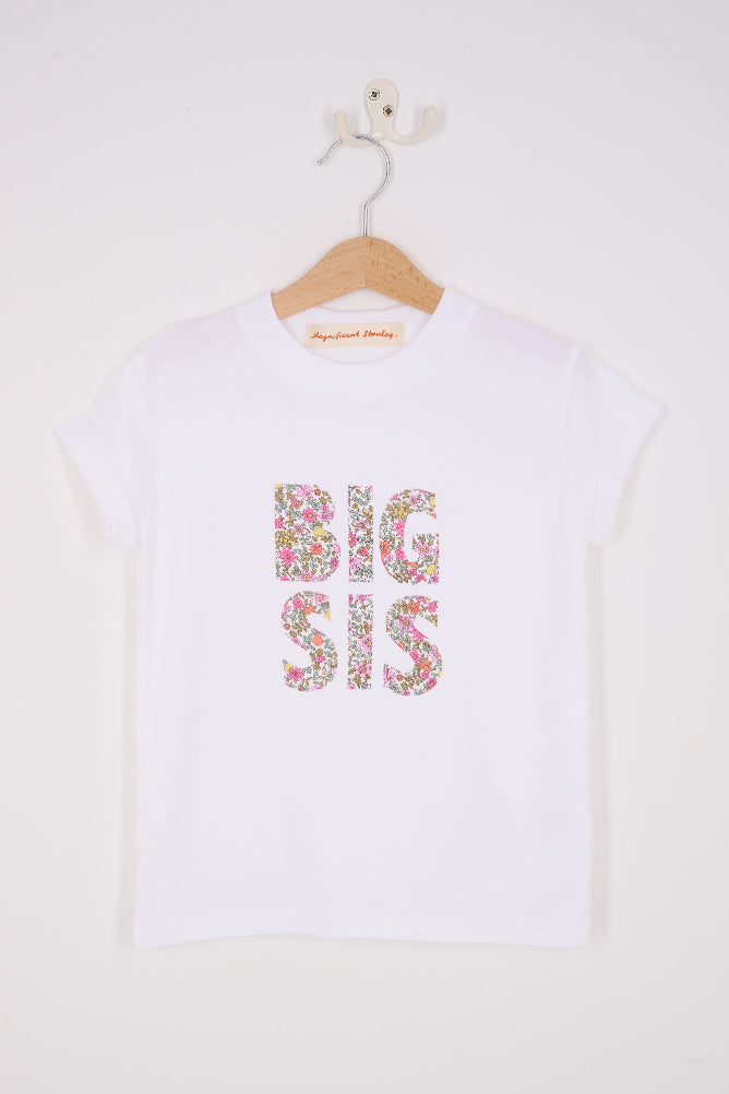 A white cotton t-shirt with BIG SIS in floral letters on the front. the letters are cut from Liberty print and appliquéd on.