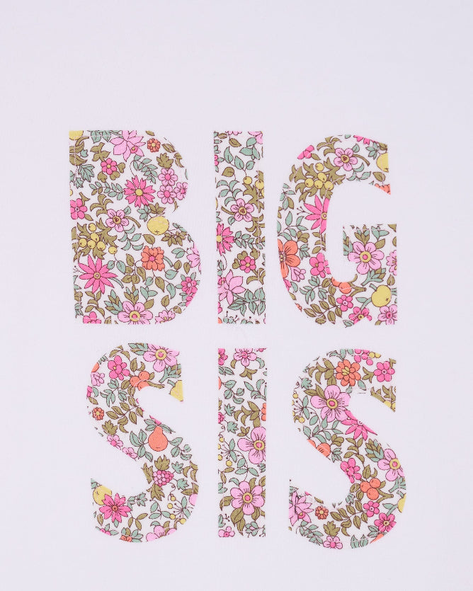 A close up pf a white cotton t-shirt with BIG SIS in floral letters on the front. the letters are cut from Liberty print and appliquéd on.