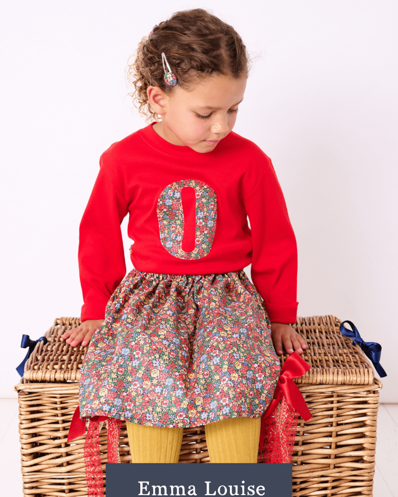 a 5 year old girl wearing a Magnificent Stanley long sleeve Red T-Shirt with her initial on the front in Emma Louise Liberty Print