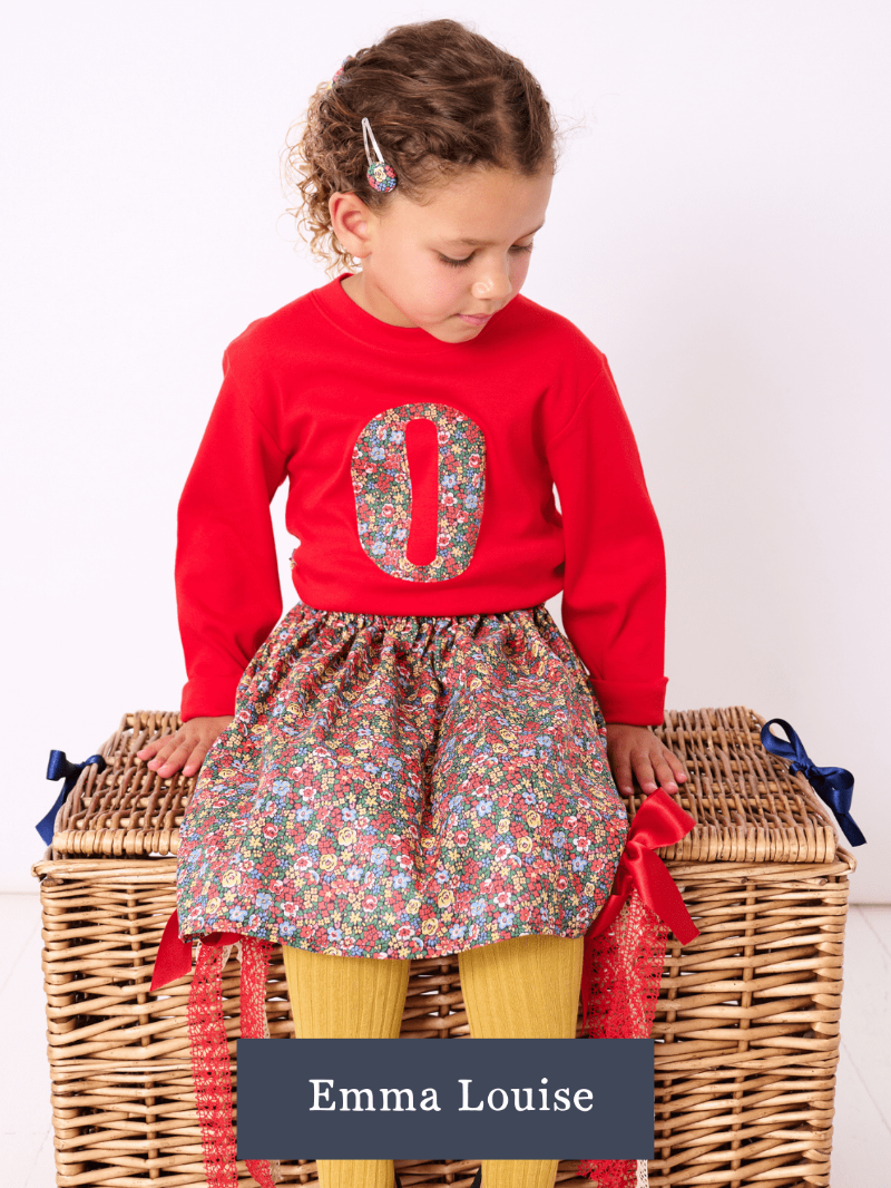 a 5 year old girl wearing a Magnificent Stanley long sleeve Red T-Shirt with her initial on the front in Emma Louise Liberty Print