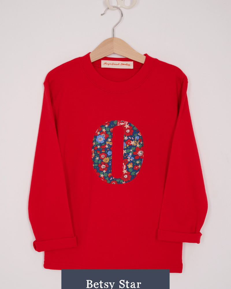 a Magnificent Stanley long sleeve Red birthday T-Shirt with an initial on the front in Betsy star Liberty Print