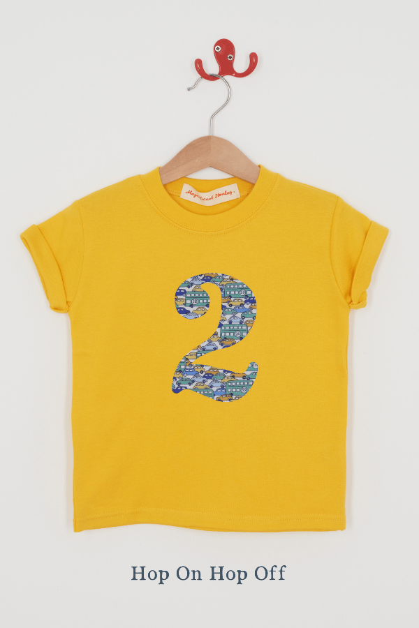 a yellow birthday t-shirt with a number 2 cut from hop on hop off liberty cars print on the front.