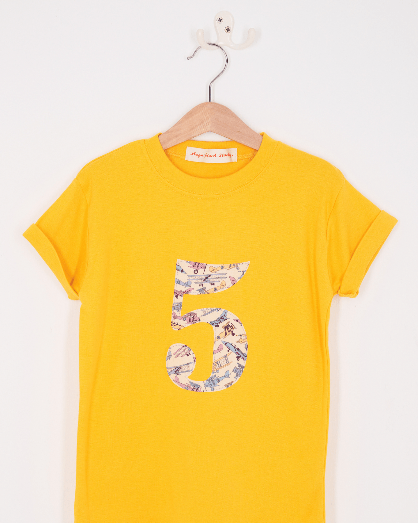 a yellow birthday t-shirt with a number 5 cut from tom's jet liberty planes print on the front.