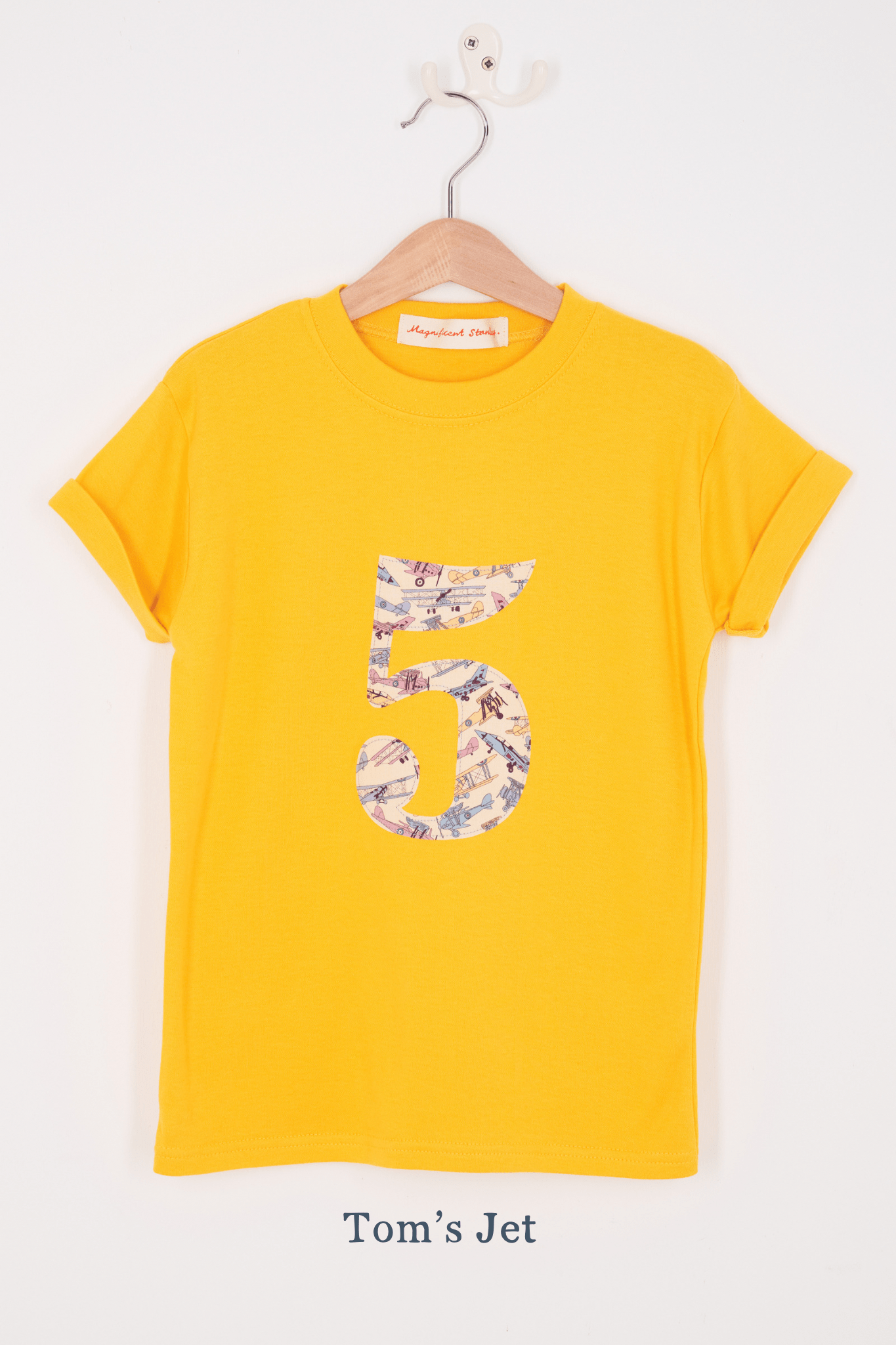 a yellow birthday t-shirt with a number 5 cut from tom's jet liberty planes print on the front.