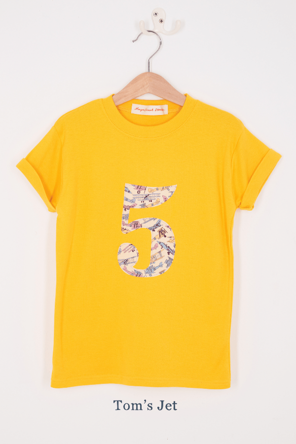 a yellow birthday t-shirt with a number 5 cut from tom's jet liberty planes print on the front.