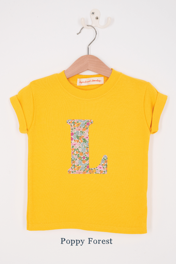 a personalised kids yellow t-shirt with an initial cut from poppy forest liberty floral print on the front