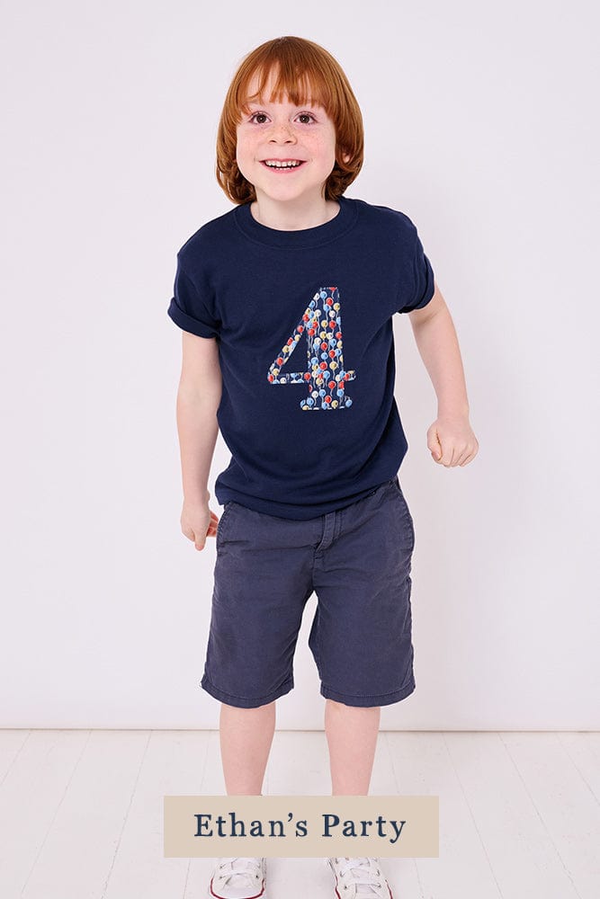 a 4 year old boy wearing a navy birthday t-shirt with a number 4 cut from ethan's party balloon liberty print on the front
