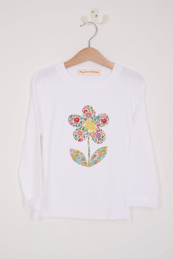 a white cotton kids Tee with a flower sewn on the front in floral liberty prints.